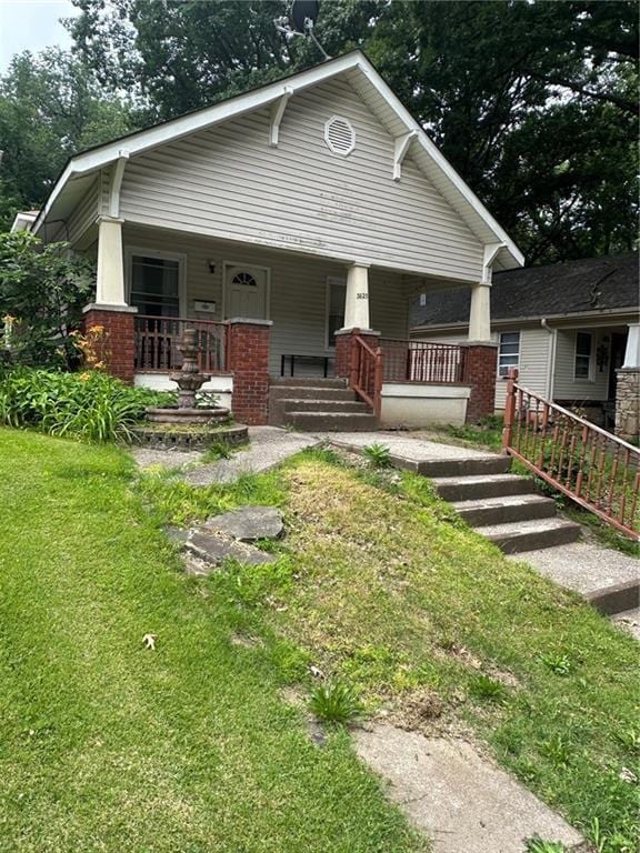 3823 Ruby Ave, Kansas City, KS 66106 - view of front of house featuring covered porch, a front lawn, and brick siding