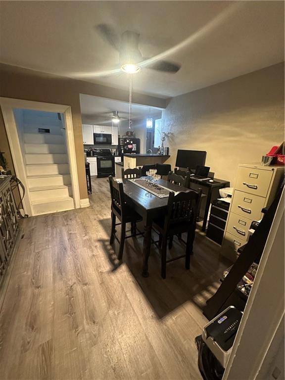 3823 Ruby Ave, Kansas City, KS 66106 - dining space with wood finished floors, stairway, and ceiling fan