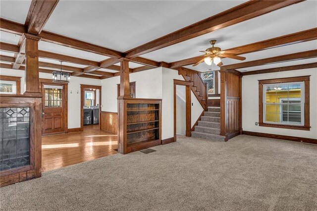 305 E Main St, Richmond, MO 64085 - unfurnished living room featuring carpet flooring, stairs, beam ceiling, wooden walls, and a wainscoted wall