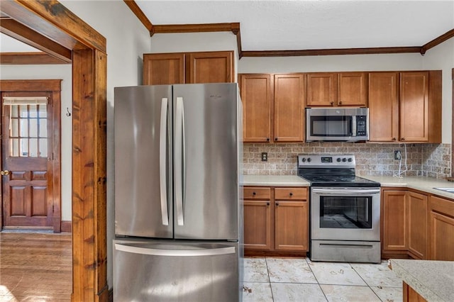 305 E Main St, Richmond, MO 64085 - kitchen featuring appliances with stainless steel finishes, crown molding, backsplash, light countertops, and brown cabinetry
