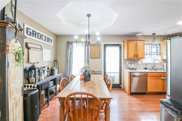 580 SE 110th St, Warrensburg, MO 64093 - kitchen with stainless steel appliances, a chandelier, light countertops, light wood-style floors, and hanging light fixtures