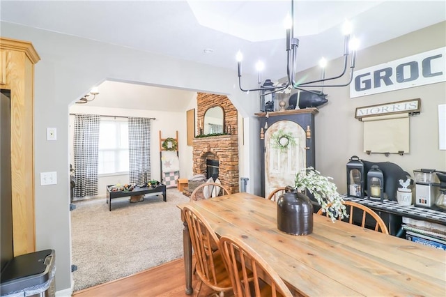 580 SE 110th St, Warrensburg, MO 64093 - dining room with a fireplace, a chandelier, and wood finished floors