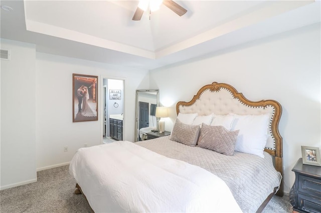 580 SE 110th St, Warrensburg, MO 64093 - bedroom with carpet floors, a raised ceiling, connected bathroom, and a ceiling fan
