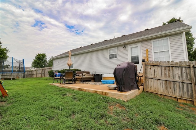 580 SE 110th St, Warrensburg, MO 64093 - rear view of house with a trampoline and a fenced backyard