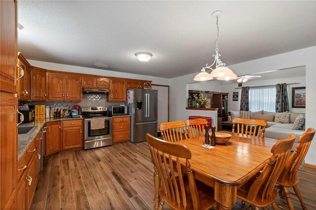 606 S Thornton St, Richmond, MO 64085 - dining area featuring dark wood finished floors and a chandelier