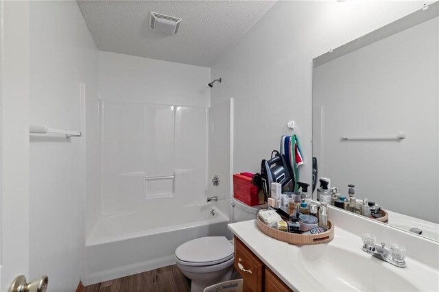 606 S Thornton St, Richmond, MO 64085 - bathroom featuring vanity, wood finished floors, tub / shower combination, and a textured ceiling