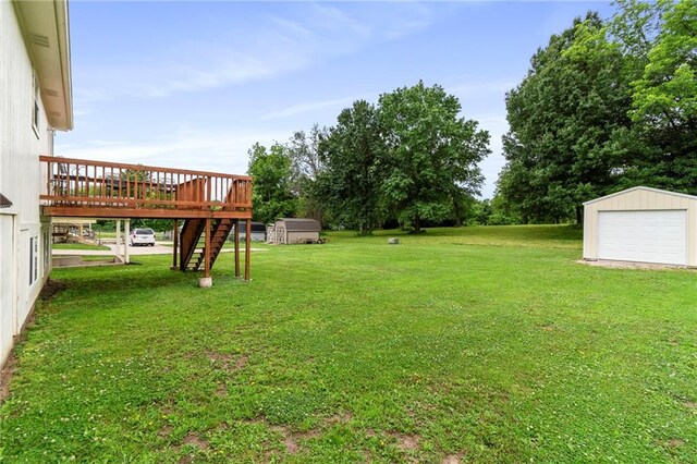 606 S Thornton St, Richmond, MO 64085 - view of green lawn with a wooden deck, stairway, a garage, and a storage shed