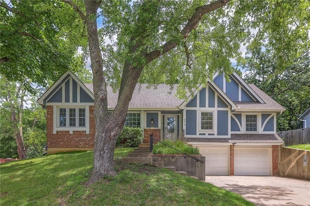 6919 Albervan St, Shawnee, KS 66216 - english style home with brick siding, a garage, driveway, and roof with shingles