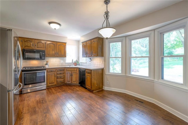 6919 Albervan St, Shawnee, KS 66216 - kitchen featuring black appliances, brown cabinetry, backsplash, and light countertops