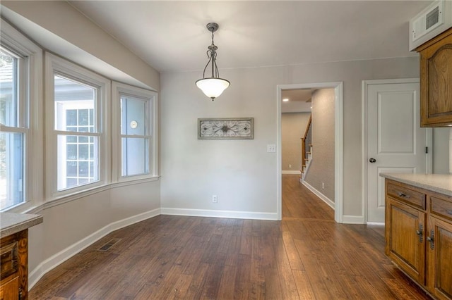 6919 Albervan St, Shawnee, KS 66216 - unfurnished dining area featuring dark wood-style floors, healthy amount of natural light, and stairway