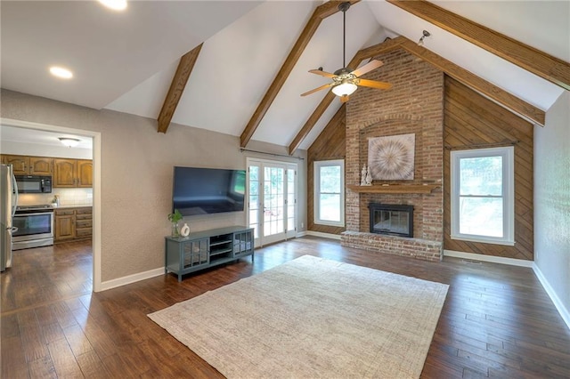 6919 Albervan St, Shawnee, KS 66216 - unfurnished living room with plenty of natural light, a ceiling fan, beamed ceiling, a fireplace, and dark wood-style flooring