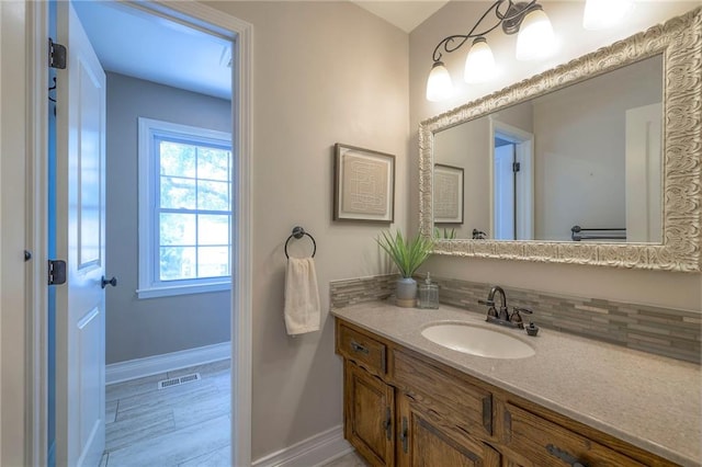 6919 Albervan St, Shawnee, KS 66216 - bathroom featuring vanity, tasteful backsplash, and wood finished floors
