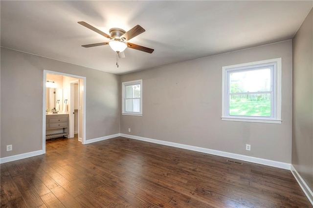 6919 Albervan St, Shawnee, KS 66216 - unfurnished bedroom with dark wood-type flooring, connected bathroom, and a ceiling fan