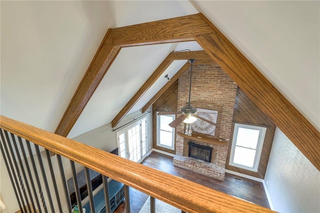 6919 Albervan St, Shawnee, KS 66216 - unfurnished living room with healthy amount of natural light, a brick fireplace, high vaulted ceiling, a ceiling fan, and beamed ceiling