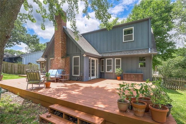 6919 Albervan St, Shawnee, KS 66216 - rear view of property with board and batten siding, roof with shingles, a chimney, and a wooden deck