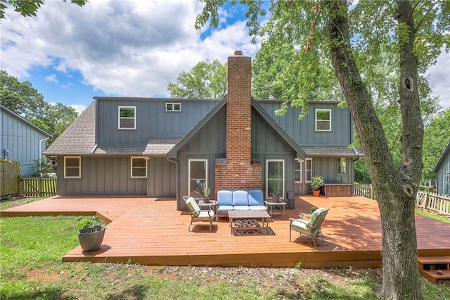 6919 Albervan St, Shawnee, KS 66216 - back of property with a chimney, board and batten siding, an outdoor hangout area, roof with shingles, and a deck