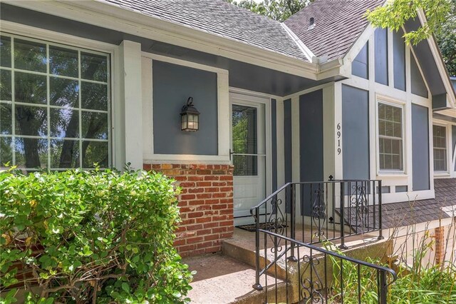 6919 Albervan St, Shawnee, KS 66216 - view of exterior entry with roof with shingles and brick siding