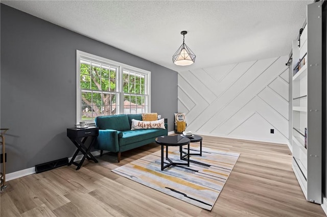 1208 SW Speas Dr, Blue Springs, MO 64014 - sitting room with wood finished floors, a textured ceiling, and a barn door