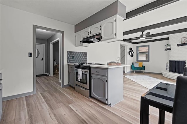 1208 SW Speas Dr, Blue Springs, MO 64014 - kitchen with stainless steel range with gas cooktop, under cabinet range hood, a ceiling fan, light wood-style floors, and open floor plan