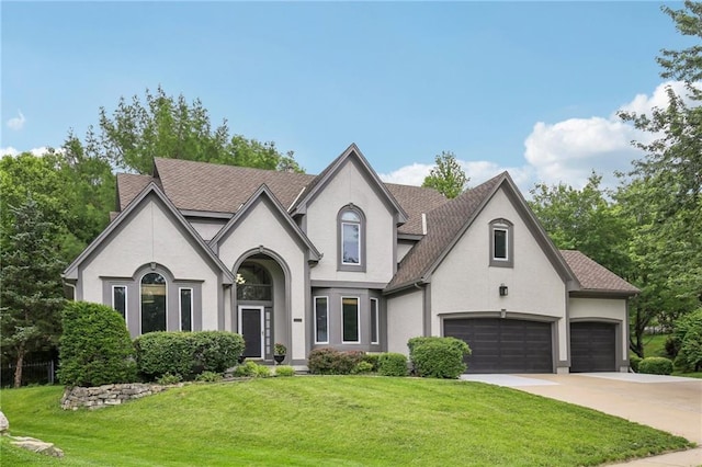 12909 Maple St, Overland Park, KS 66209 - view of front of house featuring stucco siding, a front yard, concrete driveway, and a shingled roof
