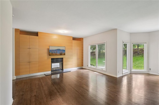 12909 Maple St, Overland Park, KS 66209 - unfurnished living room featuring dark wood-type flooring, a tile fireplace, and wood walls