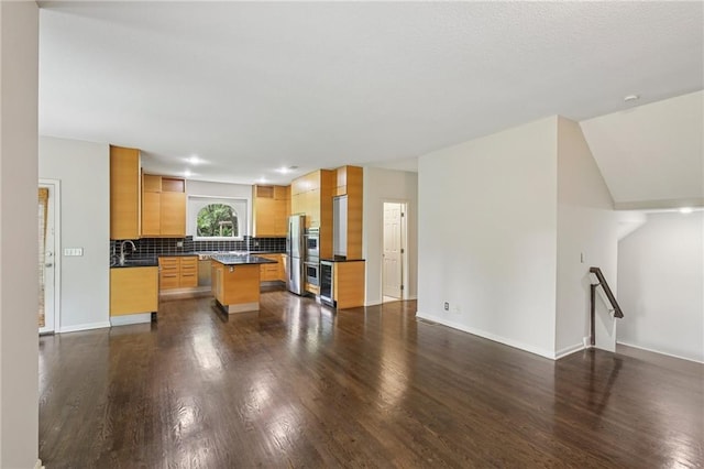 12909 Maple St, Overland Park, KS 66209 - kitchen featuring dark countertops, dark wood-style floors, a center island, open floor plan, and backsplash