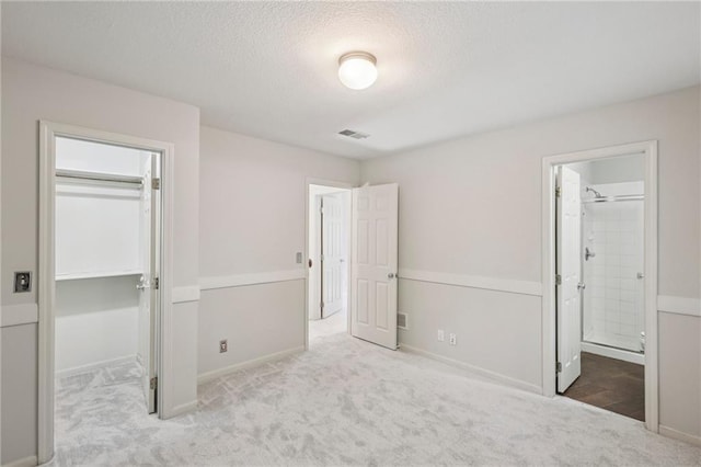 12909 Maple St, Overland Park, KS 66209 - unfurnished bedroom with carpet, a walk in closet, a textured ceiling, a closet, and ensuite bath