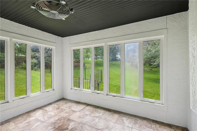 12909 Maple St, Overland Park, KS 66209 - unfurnished sunroom featuring plenty of natural light, stone finish flooring, and a textured wall