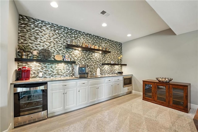 27181 W 100th Ter, Olathe, KS 66061 - indoor wet bar featuring beverage cooler, recessed lighting, tasteful backsplash, and stainless steel microwave