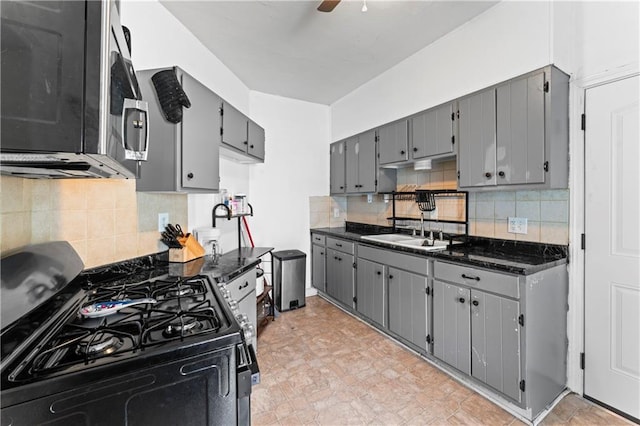 218 N 25th St, Kansas City, KS 66102 - kitchen featuring range with gas stovetop, stainless steel microwave, gray cabinets, decorative backsplash, and a ceiling fan