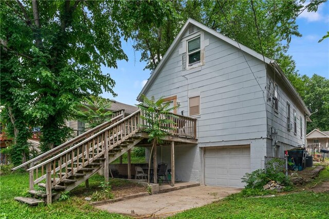 218 N 25th St, Kansas City, KS 66102 - rear view of house with a deck, stairs, a garage, and concrete driveway