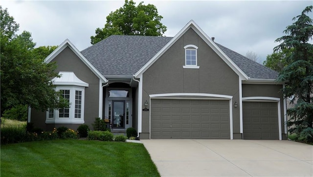 14780 S Glen Eyrie St, Olathe, KS 66061 - view of front facade featuring a garage, driveway, a front yard, stucco siding, and roof with shingles