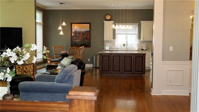 14780 S Glen Eyrie St, Olathe, KS 66061 - living area with dark wood-style floors, healthy amount of natural light, ornamental molding, and wainscoting