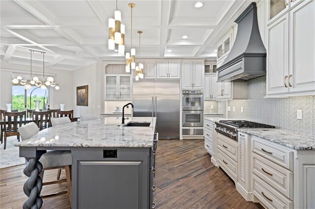18405 371st Hwy, Platte City, MO 64079 - kitchen with custom exhaust hood, appliances with stainless steel finishes, coffered ceiling, dark wood-style floors, and a chandelier