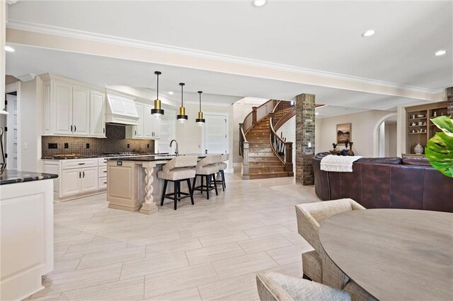 18405 371st Hwy, Platte City, MO 64079 - kitchen with open floor plan, a breakfast bar area, dark countertops, backsplash, and ornamental molding