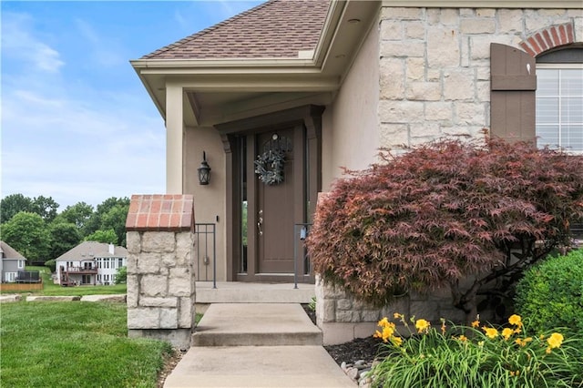 4204 SW Duck Pond Dr, Lees Summit, MO 64082 - view of exterior entry featuring stone siding, roof with shingles, and stucco siding