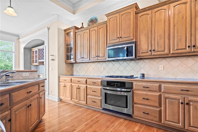 4204 SW Duck Pond Dr, Lees Summit, MO 64082 - kitchen featuring appliances with stainless steel finishes, light wood-type flooring, tasteful backsplash, ornamental molding, and pendant lighting