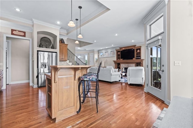 4204 SW Duck Pond Dr, Lees Summit, MO 64082 - kitchen featuring stainless steel fridge with ice dispenser, crown molding, a kitchen bar, light wood-style floors, and open shelves