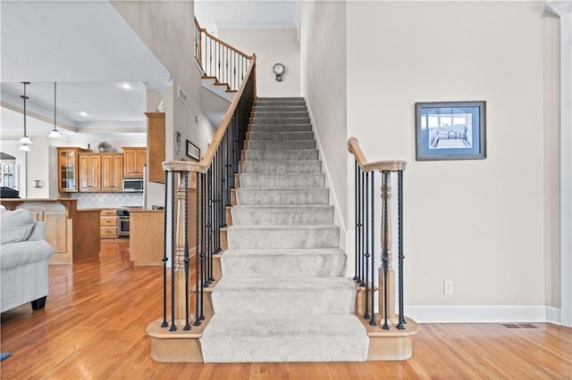 4204 SW Duck Pond Dr, Lees Summit, MO 64082 - stairs with crown molding, wood finished floors, and a towering ceiling