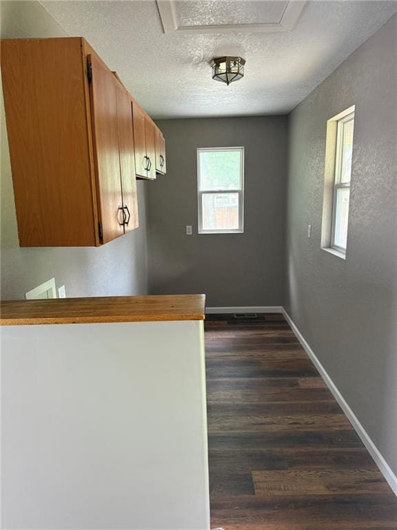 915 Des Moines St, Burlington, KS 66839 - kitchen with dark wood-style floors, a textured ceiling, and brown cabinets
