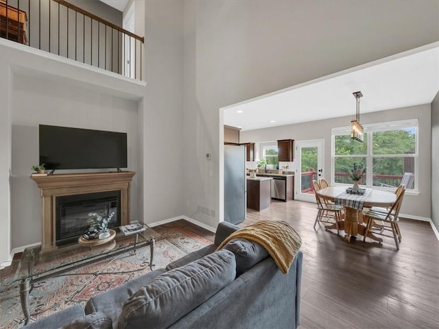 21818 W 123rd Ter, Olathe, KS 66061 - living room featuring a high ceiling, wood finished floors, a glass covered fireplace, and recessed lighting