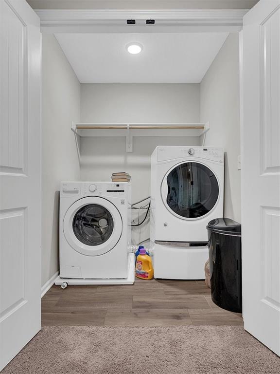 21818 W 123rd Ter, Olathe, KS 66061 - washroom featuring washer and clothes dryer, carpet floors, and wood finished floors