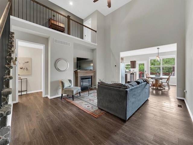 21818 W 123rd Ter, Olathe, KS 66061 - living room with a glass covered fireplace, a towering ceiling, dark wood-style flooring, a ceiling fan, and recessed lighting