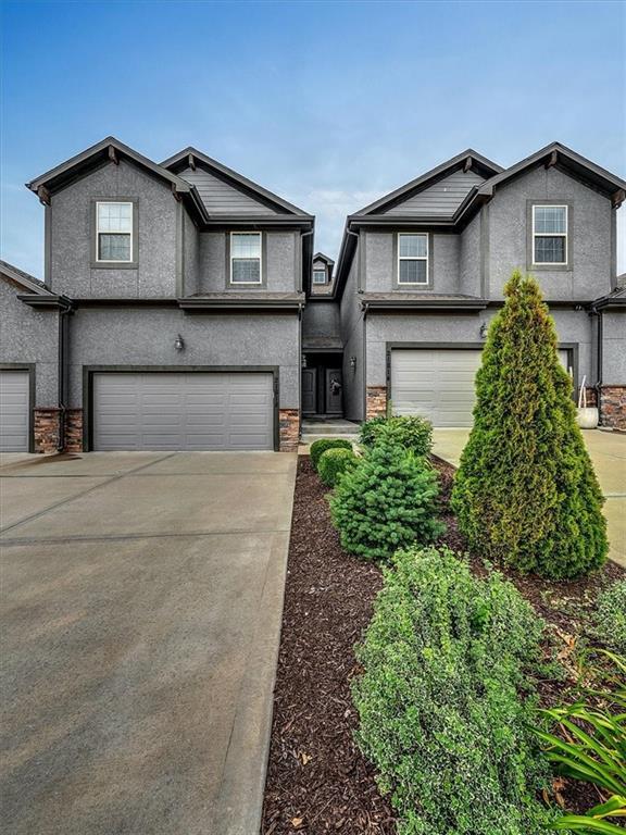 21818 W 123rd Ter, Olathe, KS 66061 - view of front of property with an attached garage, concrete driveway, stucco siding, and stone siding