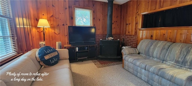 28767 Parkway Dr, Warsaw, MO 65355 - living room featuring wood walls, a wood stove, and carpet