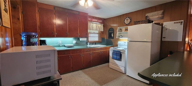 28767 Parkway Dr, Warsaw, MO 65355 - kitchen with white appliances, ceiling fan, light colored carpet, light countertops, and wood walls
