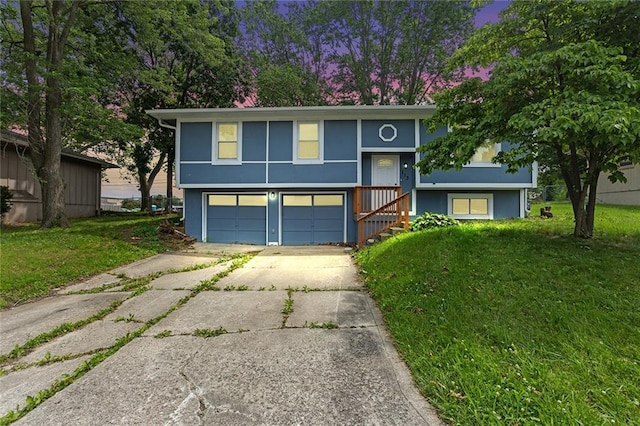 113 SW 21st St, Oak Grove, MO 64075 - split foyer home featuring concrete driveway, a garage, a front yard, and stucco siding