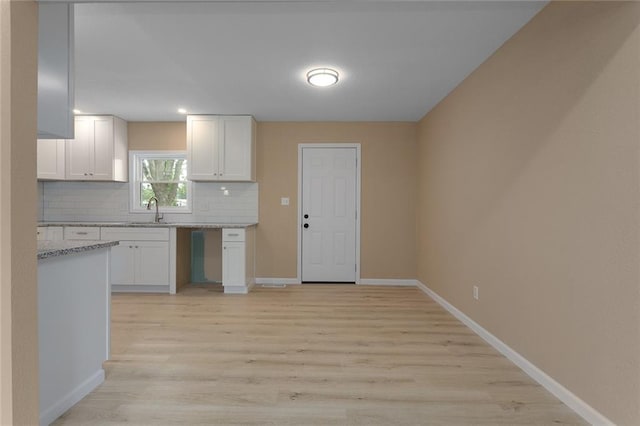 113 SW 21st St, Oak Grove, MO 64075 - kitchen featuring backsplash, white cabinets, light wood finished floors, and light stone countertops