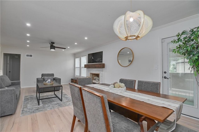 7824 Terrace St, Kansas City, MO 64114 - dining room featuring a fireplace, light wood finished floors, recessed lighting, ceiling fan, and ornamental molding
