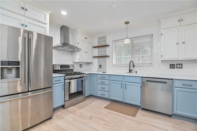 7824 Terrace St, Kansas City, MO 64114 - kitchen featuring stainless steel appliances, wall chimney exhaust hood, blue cabinets, open shelves, and crown molding